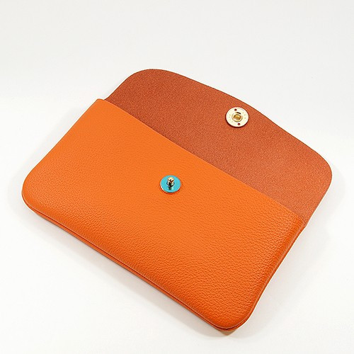 ボタンを開けたオレンジ色のドイツシュリンクカブセ型長財布