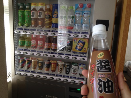 醤油サイダーをもって自販機を見ている人