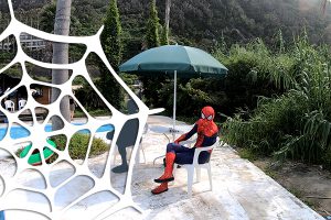 椅子に座っているスパイダーマンの恰好をした男性