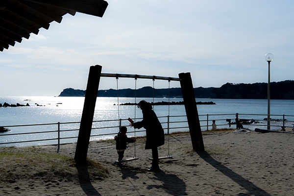 勝浦フォトスポット＿海の見えるブランコ親子の画像